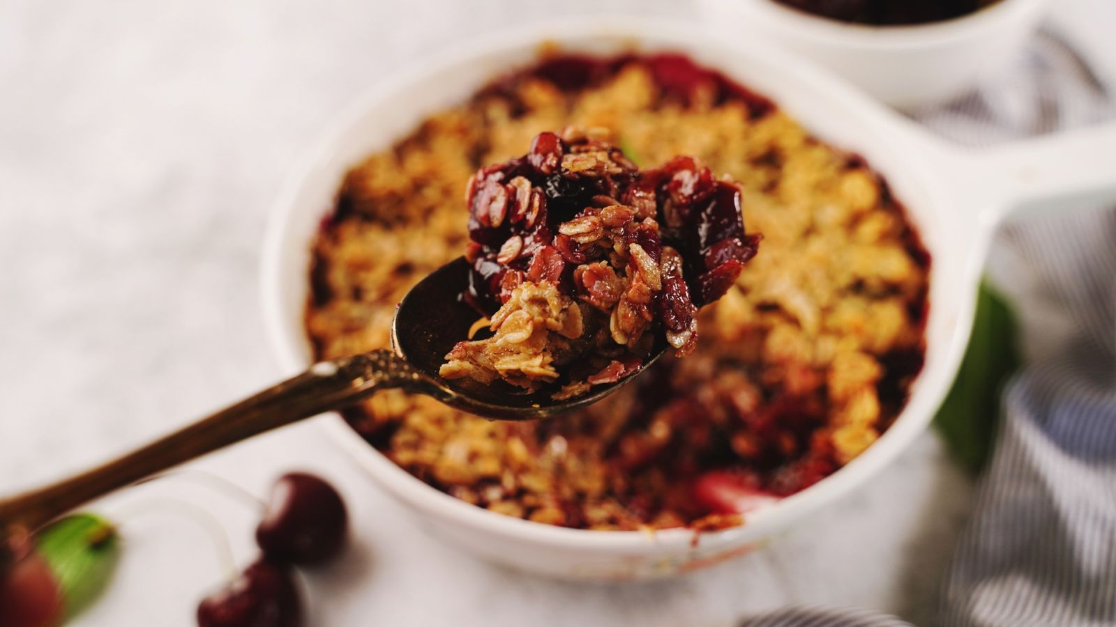 Spoonful of cherry baked oats in a white ramekin – healthy high-protein breakfast idea made with oats, banana, and berries